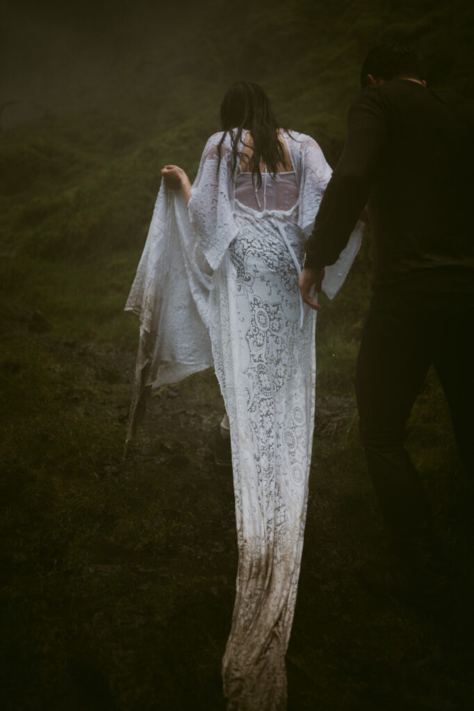 A detail shot of the bride's soaked and muddy dress as she walks away from the camera.