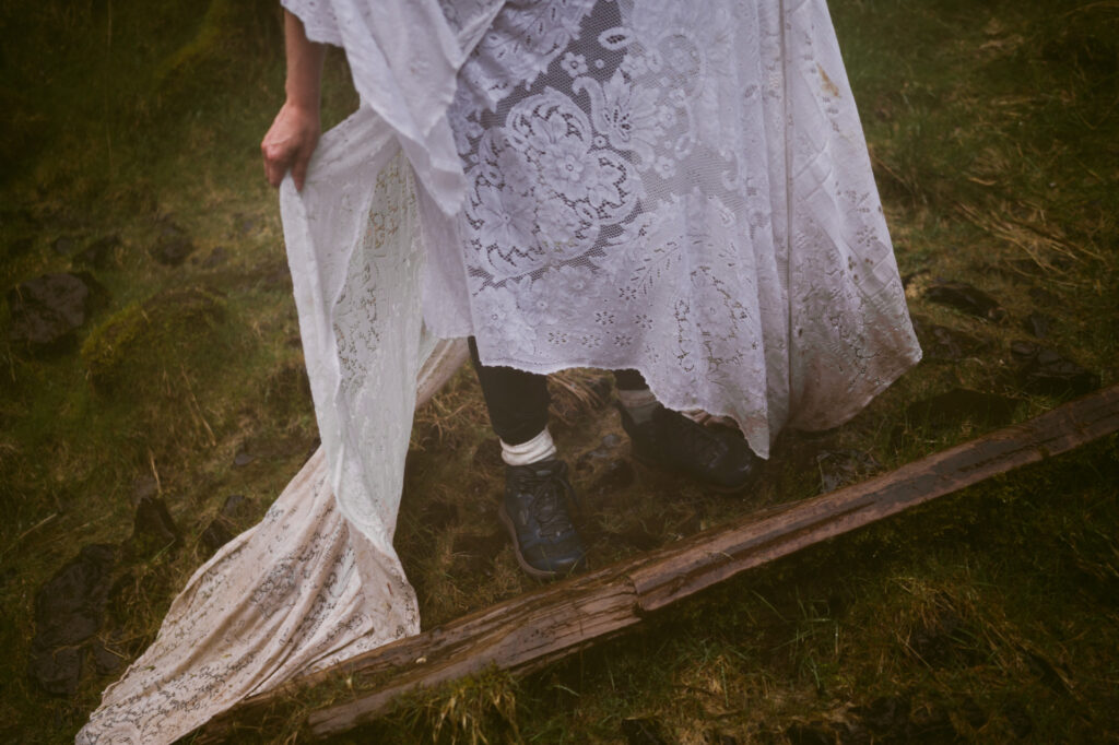 A detail shot of the bride's soaked and muddy dress as she walks away from the camera.