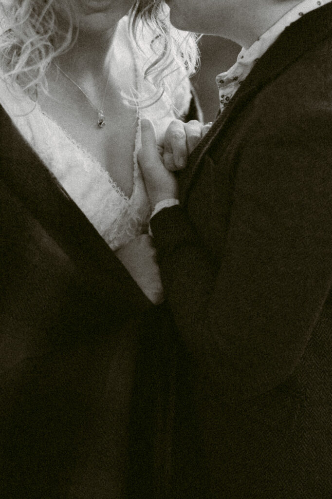 A close-up black and white image of two women holding hands.