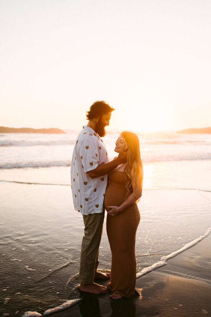 A husband and wife take maternity photos during sunset at Seal Rock Recreation Site in Seal Rock, Oregon.