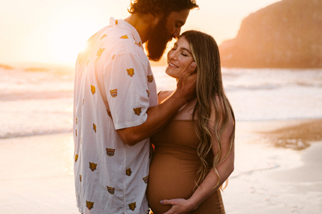 A husband and wife take maternity photos during sunset at Seal Rock Recreation Site in Seal Rock, Oregon.