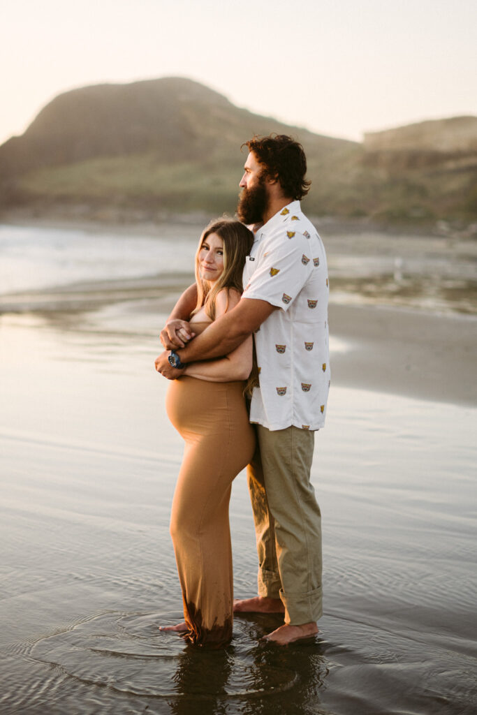 A young couples takes maternity photos at Seal Rock Recreation Site in Seal Rock, Oregon.