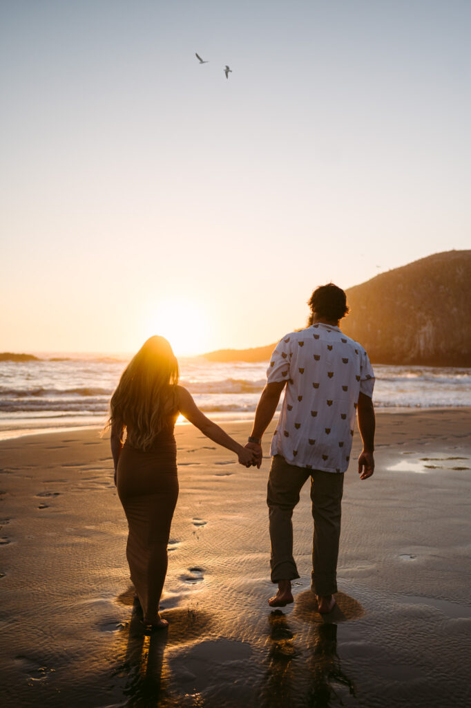 A pregnant woman and man take maternity photos at sunset at Seal Rock Recreation Site in Seal Rock, Oregon.