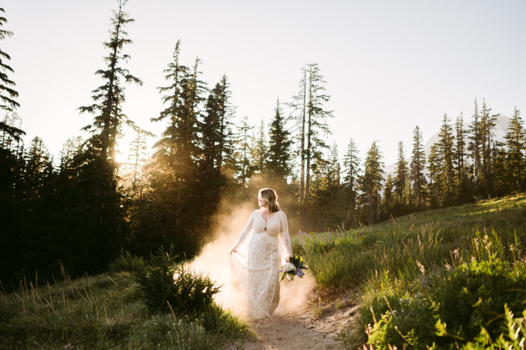 A bride hikes down Mount Hood on her wedding day at Mount Hood Meadows. She's kicking up clouds of dust, staining and dress and catching in the late summer sunlight.