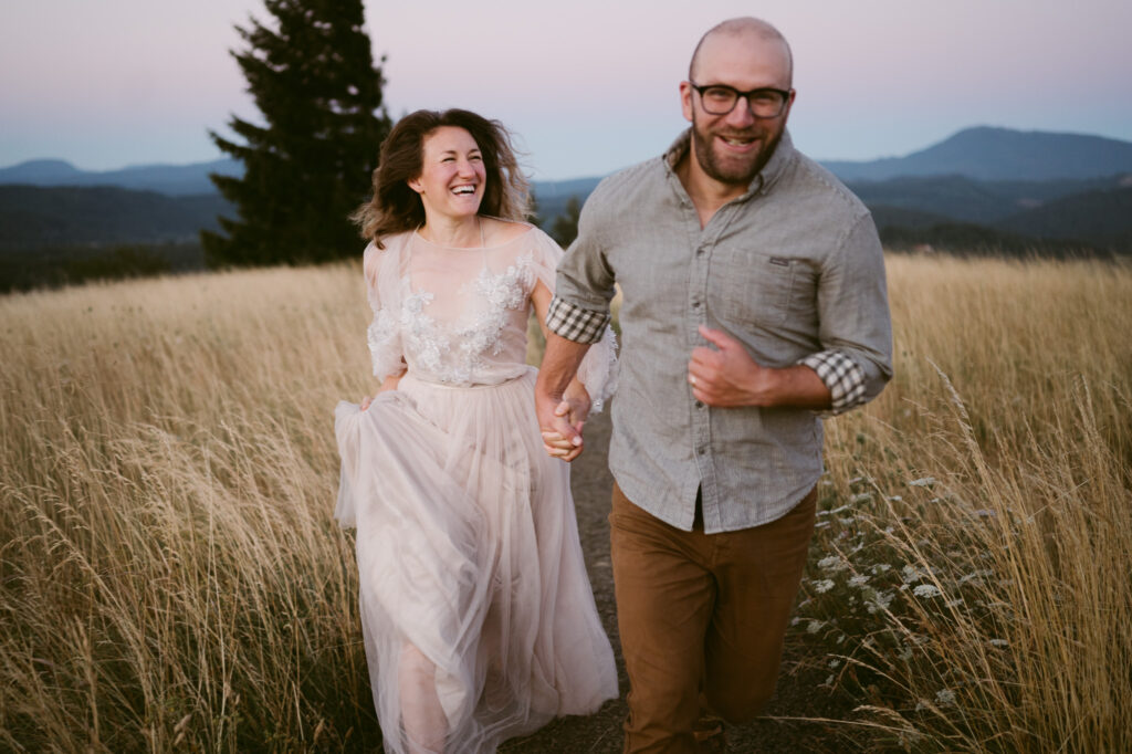 A man and woman hold hands and run up a footpath at Fitton Green in Corvallis, Oregon.