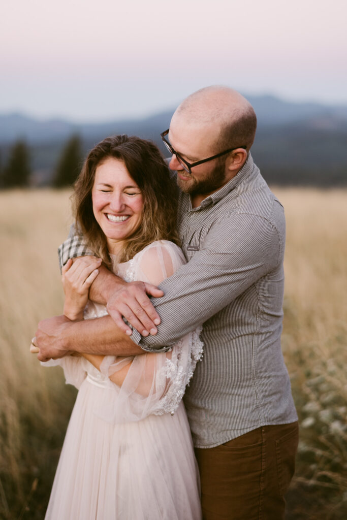 A man embraces a woman from behind during their anniversary session at Fitton Green.