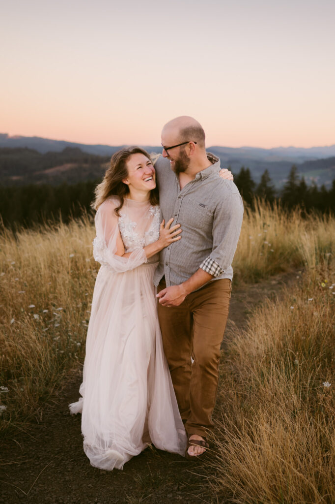 A man wraps his shoulder over a woman and pulls her in close during their engagement session at Fitton Green in Corvallis, Oregon.