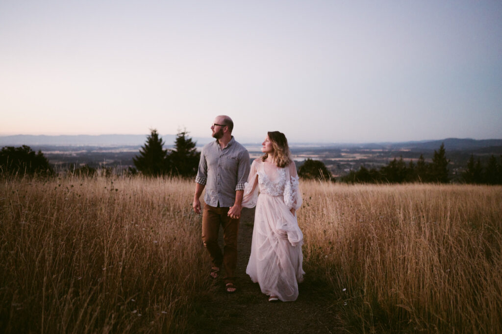 A married couple walk hand-in-hand along a footpath at Fitton Green in Corvallis, Oregon at sunrise.