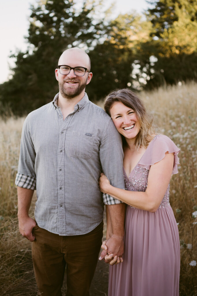 A young man and woman smile at the camera while posing for their anniversary photos at Fitton Green Natural Area in Corvallis, Oregon.