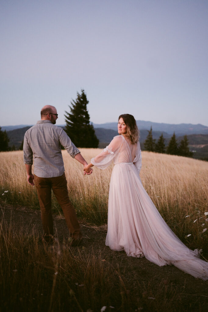 A married couple walk hand-in-hand along a footpath at Fitton Green in Corvallis, Oregon at sunrise.