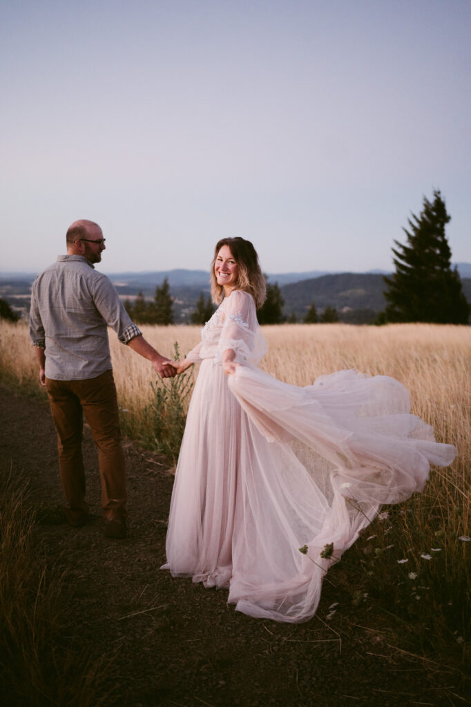 A married couple walk hand-in-hand along a footpath at Fitton Green in Corvallis, Oregon at sunrise.