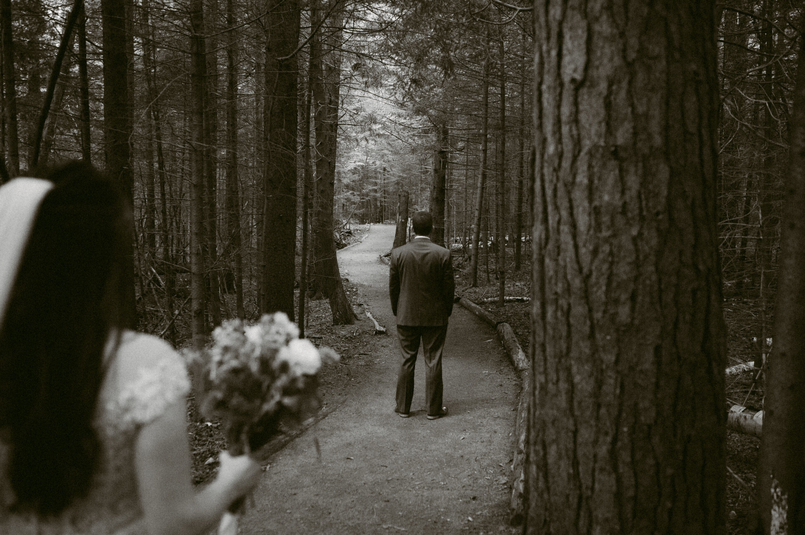 A black-and-white shot captures Martha’s perspective as she approaches Eric from behind, bouquet in hand. The simplicity of the scene heightens the anticipation of their first look, making the moment feel even more timeless.