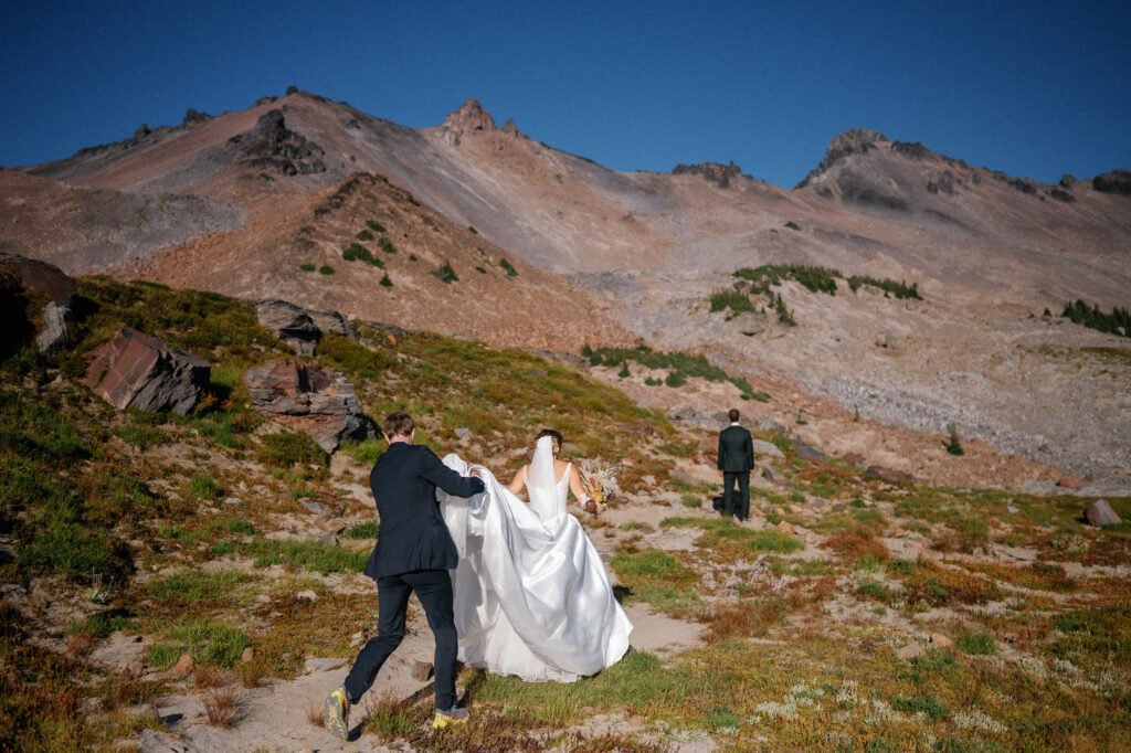 Bride approaching the groom at their first look location for their PCT elopement, surrounded by rocky terrain and dramatic ridgelines in Goat Rocks Wilderness.