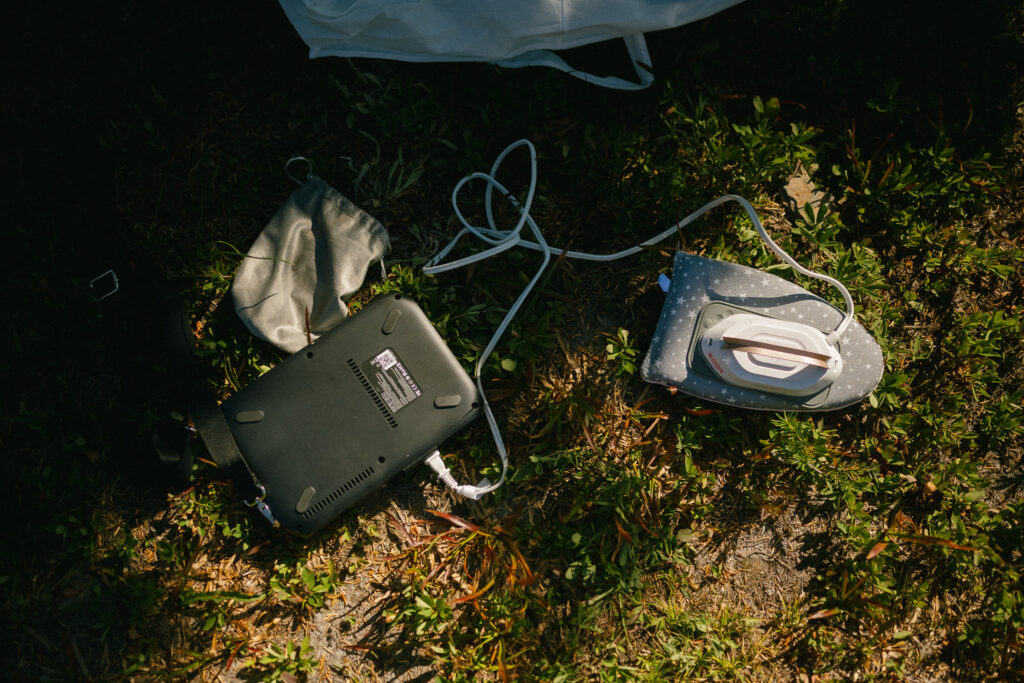 Portable iron and power station set up on the trail, part of a DIY prep scene during a backcountry wedding in Goat Rocks Wilderness.