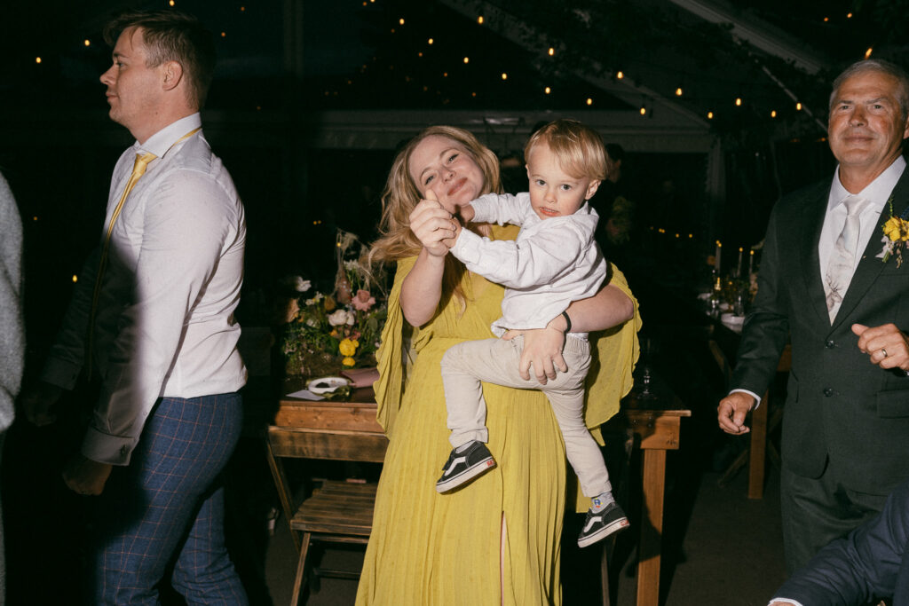 Black and white photo of guests dancing energetically on the checkered dance floor beneath a clear tent at the Griffin House.
