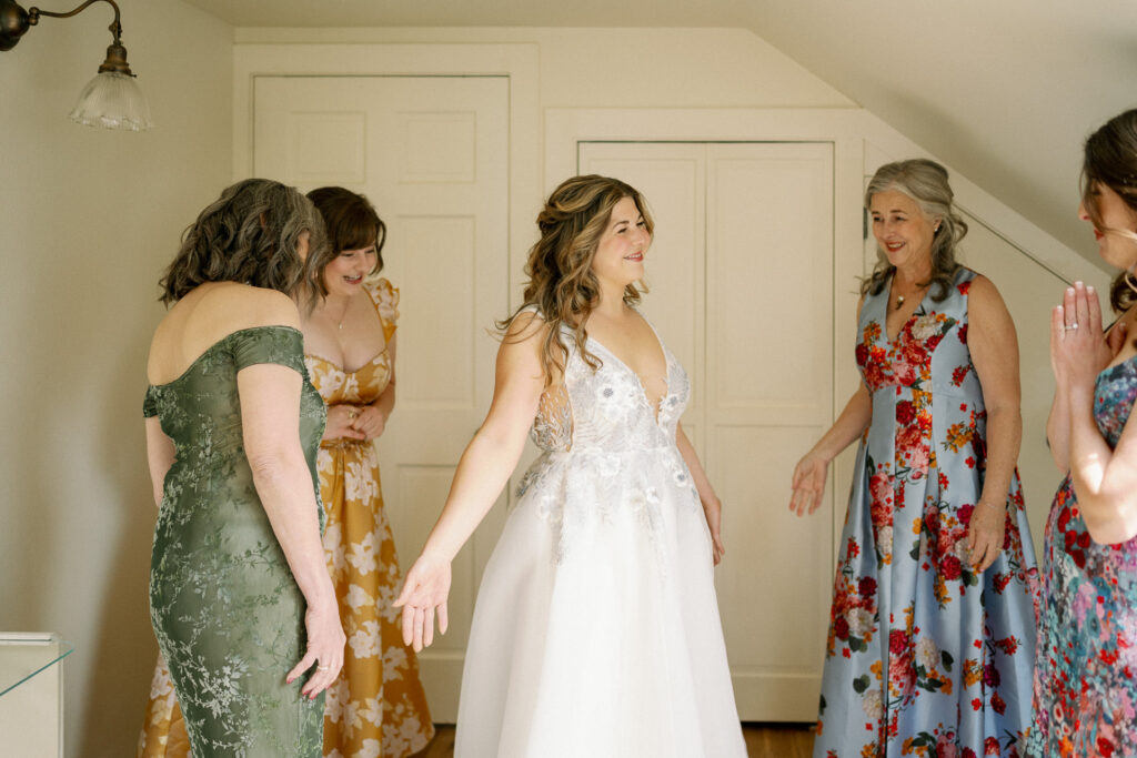 Flat lay of floral boutonnieres arranged on a wooden board, featuring white blooms, greenery, and soft textural elements.