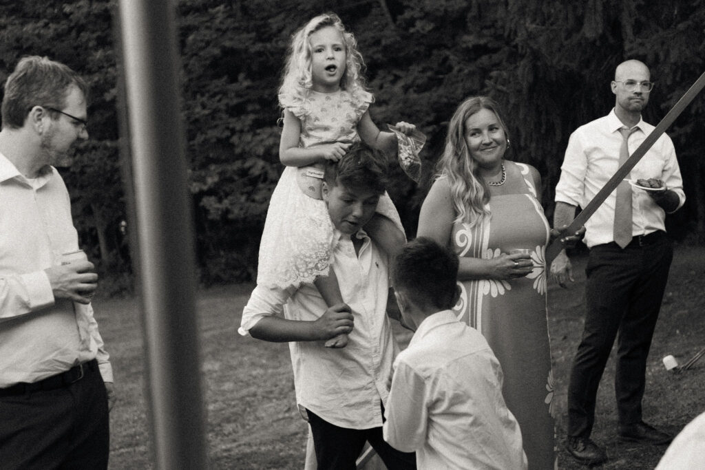 Guests chatting and children playing during the lakeside reception at the White House on the Lake.