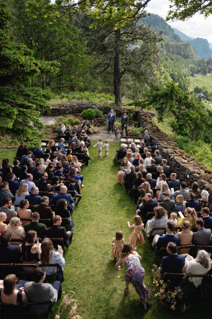 Overhead view of an intimate outdoor wedding ceremony at the Griffin House in Oregon, with guests seated along a grassy aisle.