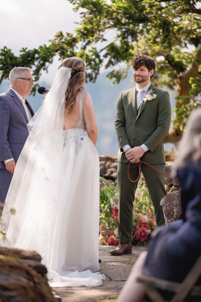 The couple exchanging vows during a joyful summer wedding at the Griffin House, framed by florals and Gorge scenery.