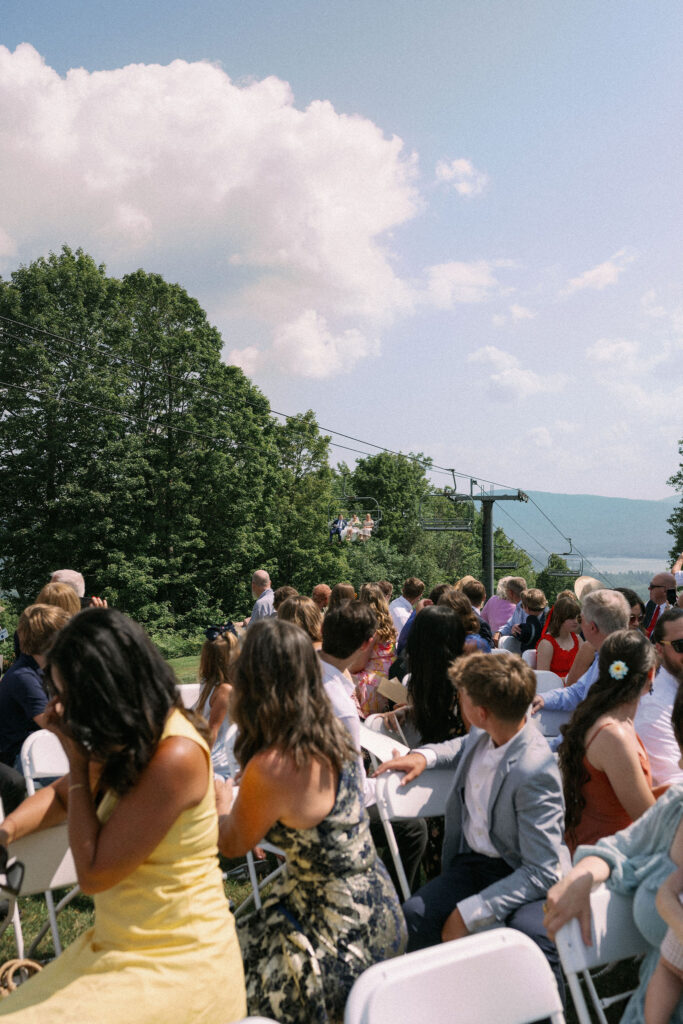 Guests seated at Oak Mountain look toward the arriving chairlift, where additional guests are riding up to the ceremony site.