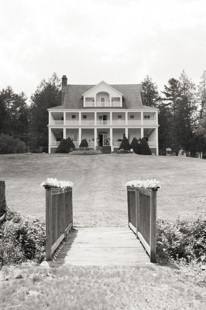 Black-and-white photo of the White House on the Lake estate, viewed from across the footbridge.