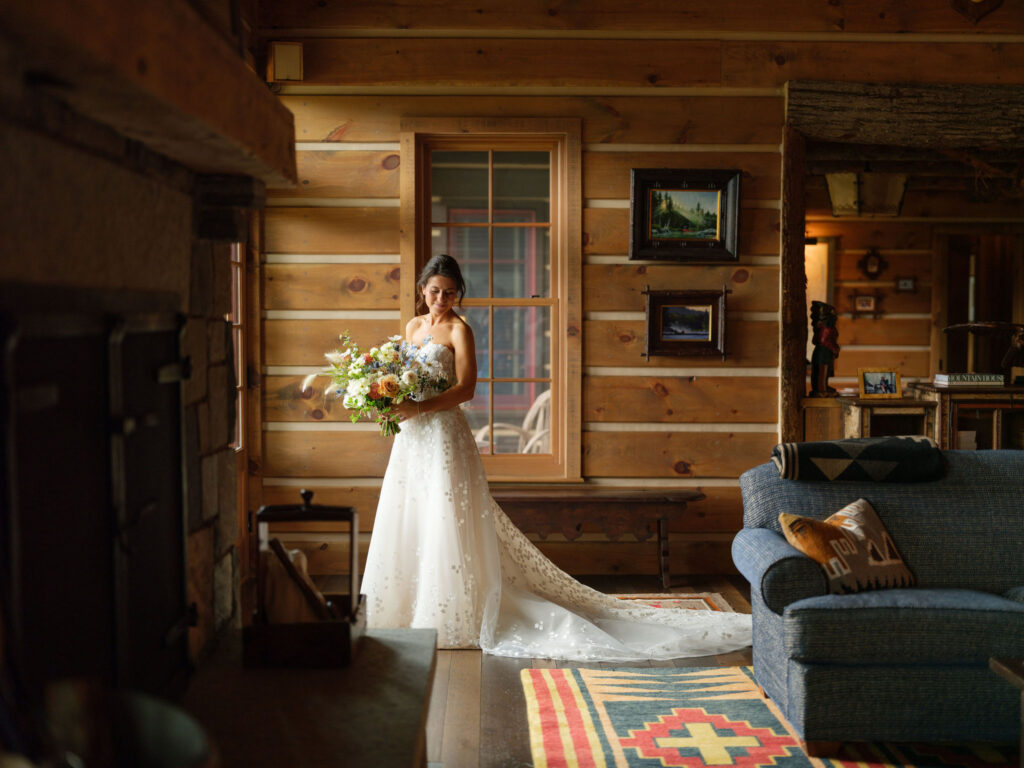 Bride in lace gown inside Adirondack cabin during a Lake Placid private estate wedding