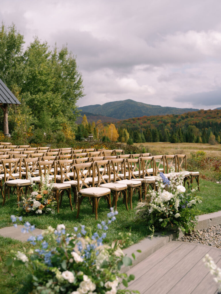 Outdoor ceremony setup with wooden chairs and Adirondack mountain views at a Lake Placid wedding