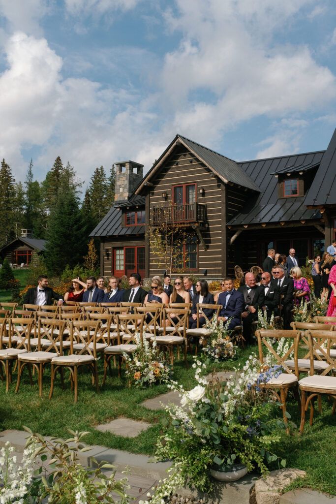 Outdoor wedding ceremony at Lake Placid private estate with rustic cabin and Adirondack mountain views
