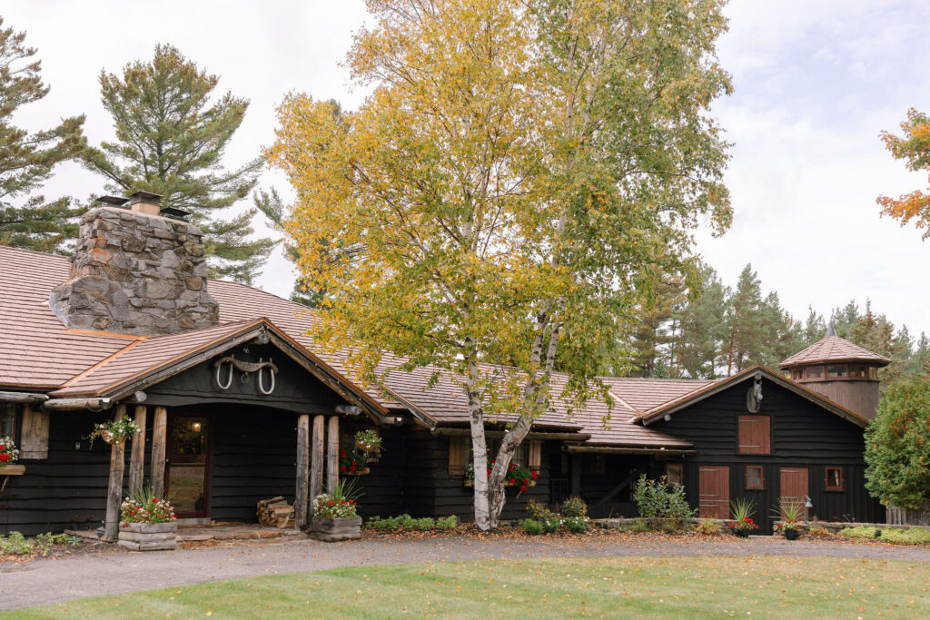 River Ranch Lake Placid exterior with rustic lodge architecture and fall trees surrounding property