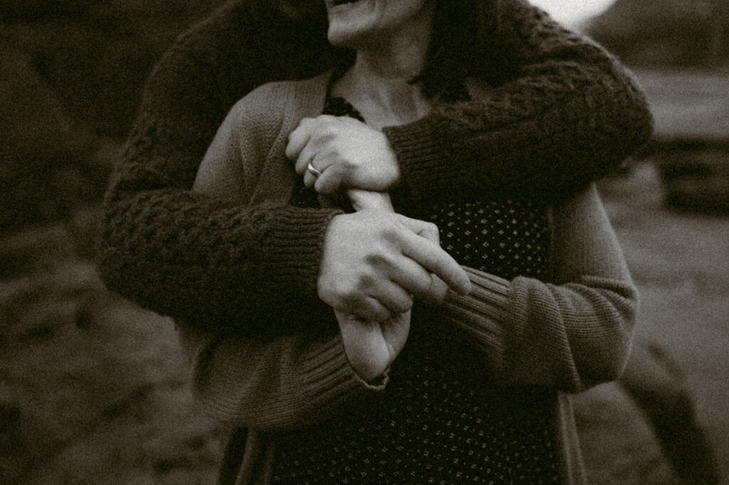 A black and white image of hands clasped together.