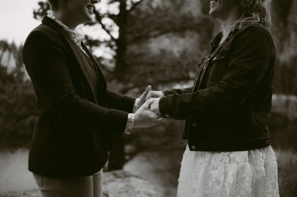 A black and white image of two women holding hands.
