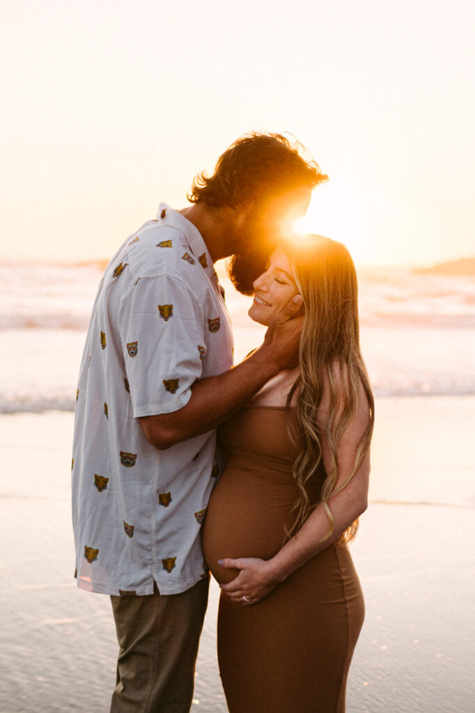 A husband and wife take maternity photos during sunset at Seal Rock Recreation Site in Seal Rock, Oregon.