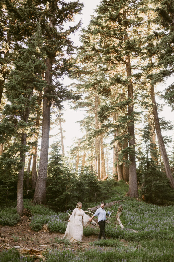 A groom leads his bride down a hiking trail during their Mount Hood Meadows elopement.