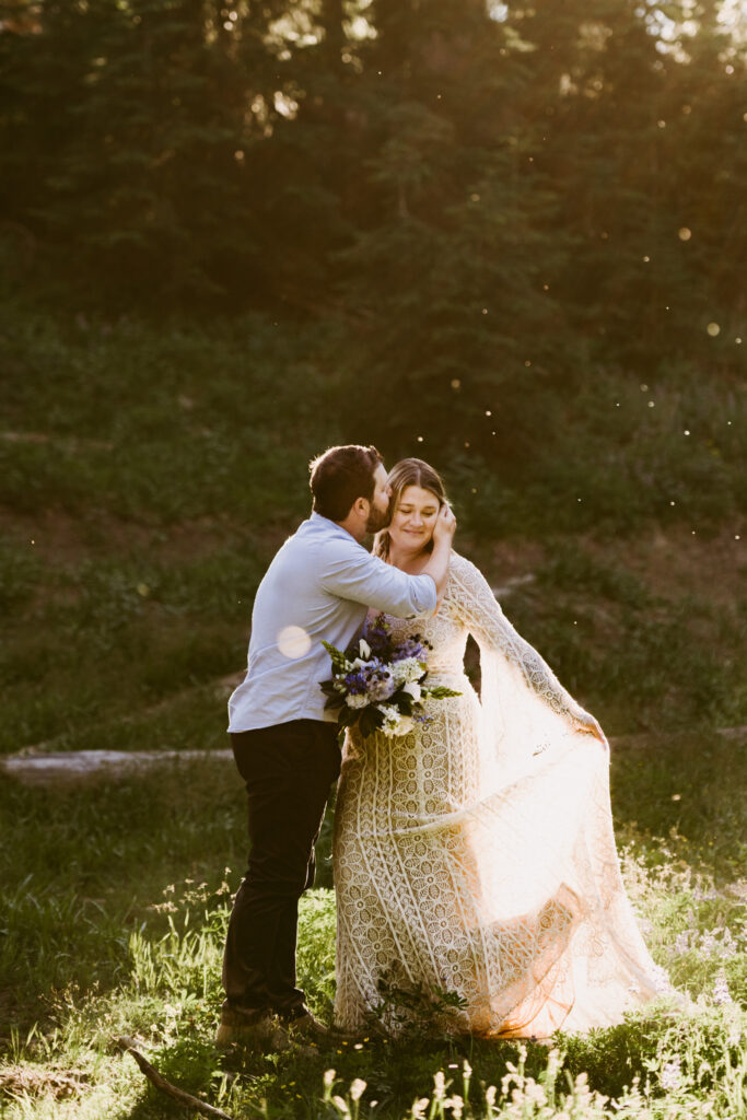 A bride and groom stand in a ray of sun on Mount Hood during their Mount Hood Meadows wedding.