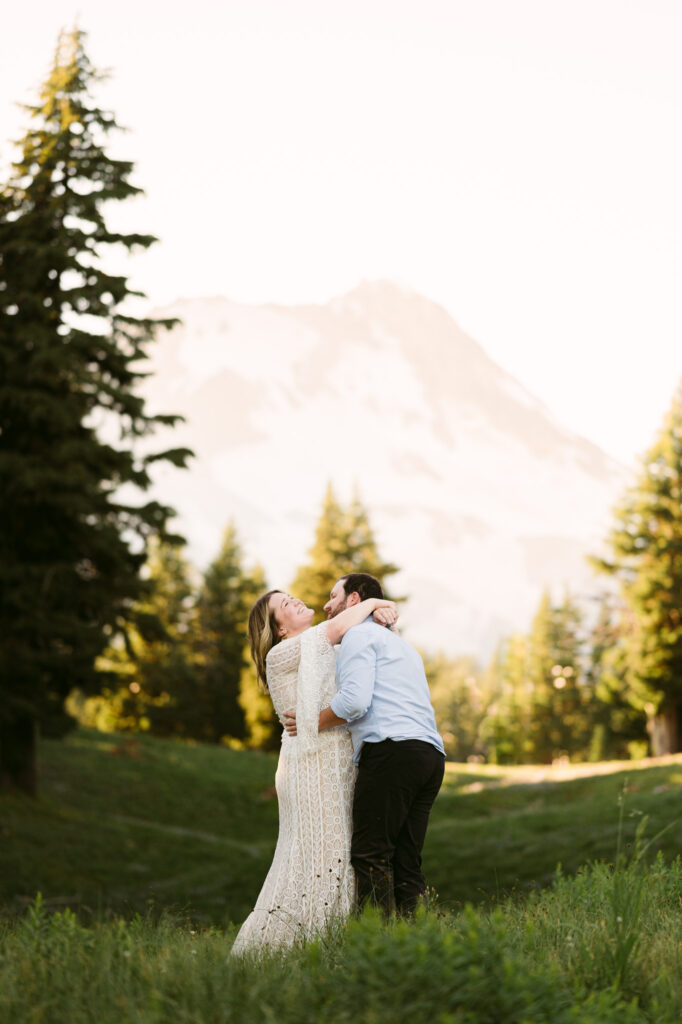 A bride and groom share a carefree embrace on a Mount Hood hiking trail during their adventure hiking elopement.