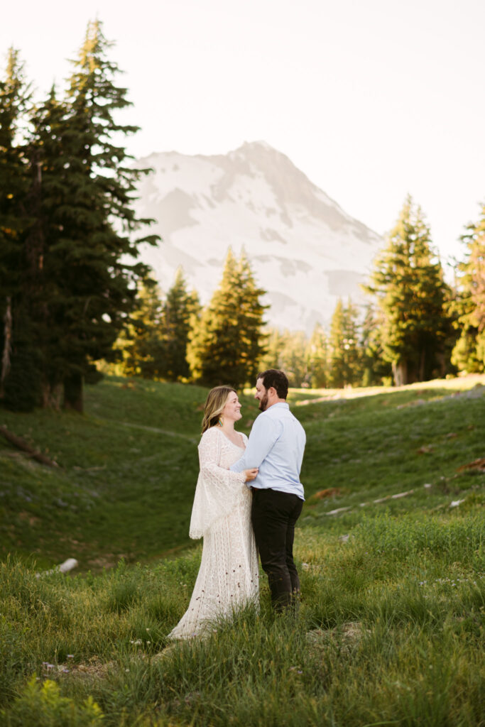 A bride and groom hike down Mount Hood on their wedding day. The summit of Hood can be seen in the background.