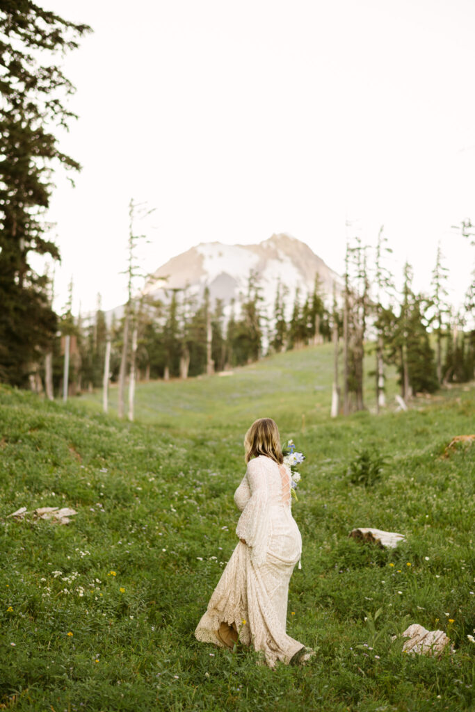 A bride looks towards the summit of Mount Hood during her elopement at Mount Hood Meadows Ski Resort.