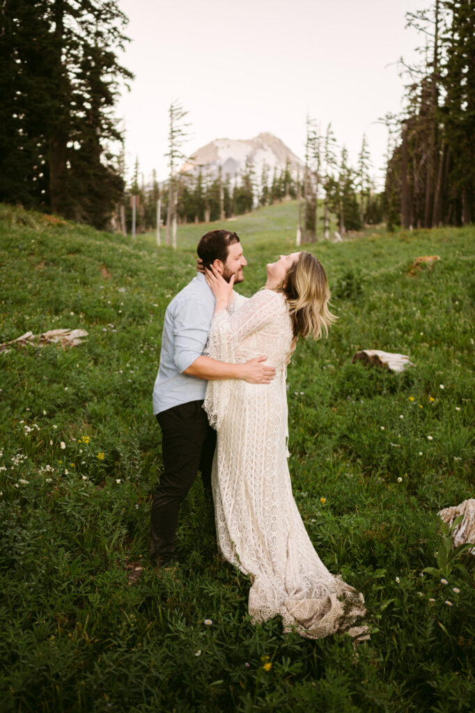 A bride and groom share a laugh in front of the summit of Mount Hood during their Mount Hood Meadows wedding.