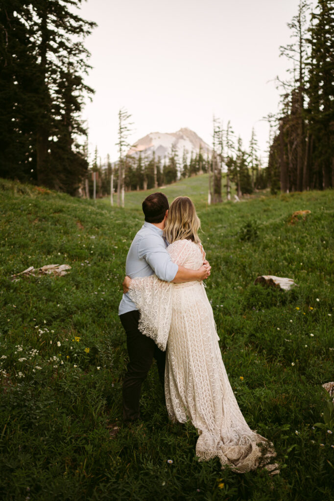 A bride and groom share a final moment of peace together as they watch the last bit of sunlight fade on the summit of Mount Hood on their wedding day.