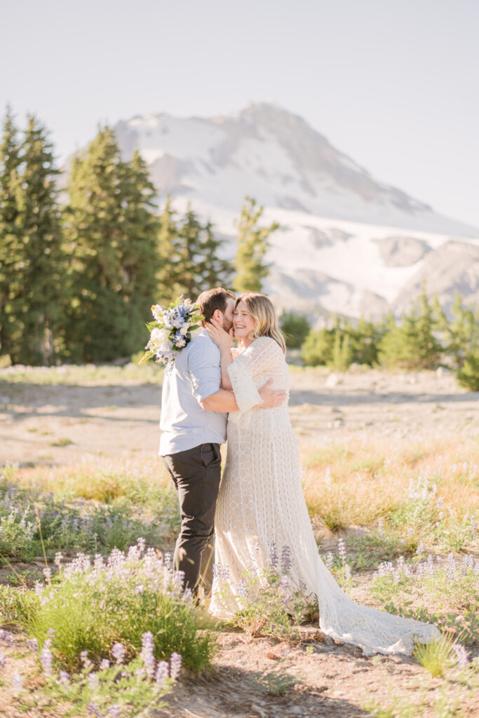 A bride and groom kiss while exploring Mount Hood Meadows during their late summer hiking elopement