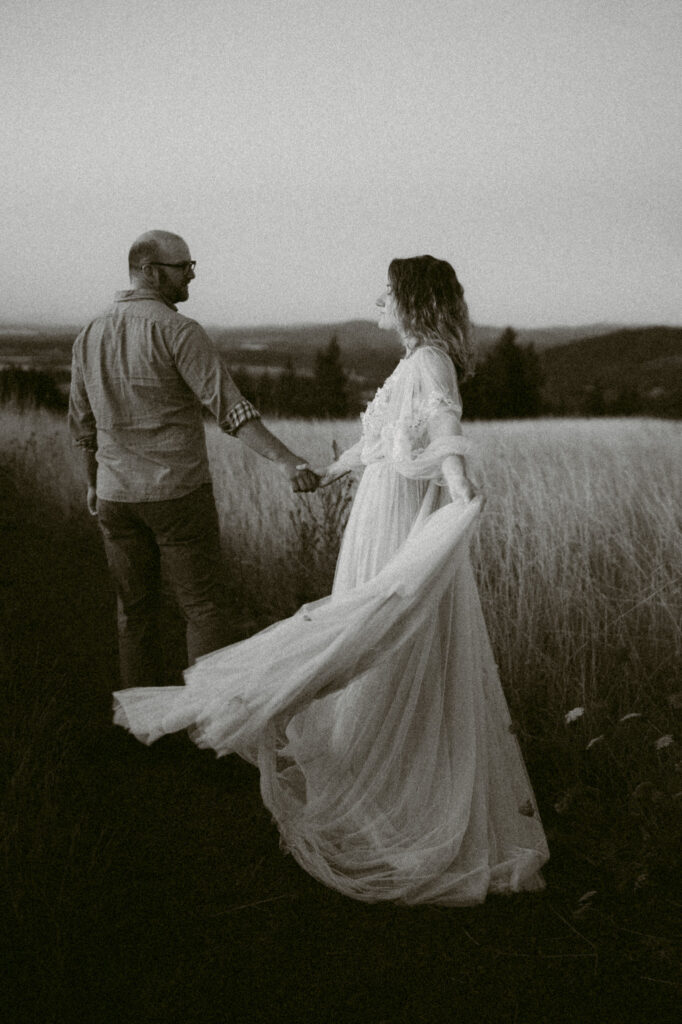 A married couple walk hand-in-hand along a footpath at Fitton Green in Corvallis, Oregon at sunrise.