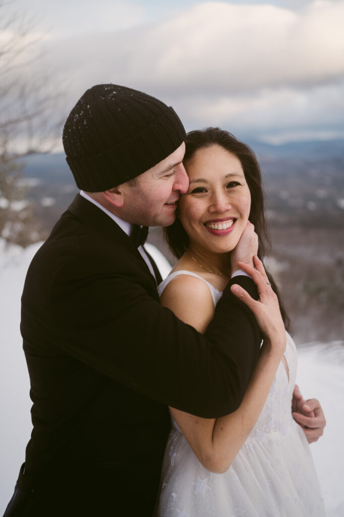 A groom holds his bride close as they elope in the Adirondacks.